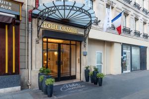 une entrée avec des plantes en pot devant un bâtiment dans l'établissement Hotel Camille Paris Tapestry Collection by Hilton, à Paris