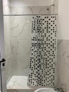 La salle de bains est pourvue d'une douche avec rideau de douche. dans l'établissement Apartamento Entero a minutos del aeropuerto, à Ezeiza