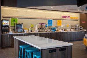 a food counter in a store with blue stools at Tru By Hilton Naperville Chicago in Naperville