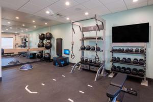 ein Zimmer mit einem Fitnessraum mit einem Haufen Gewichten in der Unterkunft Tru By Hilton Naperville Chicago in Naperville