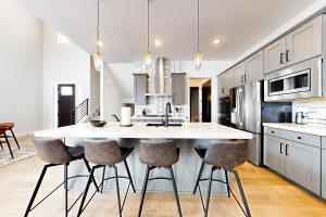 a kitchen with a large white island with bar stools at Purple Flower in Park City