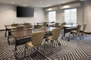 a conference room with tables and chairs and a screen at Homewood Suites by Hilton Cathedral City Palm Springs in Cathedral City