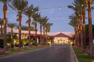 a driveway leading to a resort with palm trees and lights at The Scottsdale Resort & Spa, Curio Collection by Hilton in Scottsdale