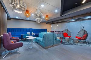 a waiting room with blue chairs and red chairs at Tru By Hilton Lexington University Medical Center, Ky in Lexington