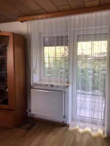 um quarto com duas grandes janelas com cortinas brancas em Turmhaus Trieben Wohnung 2 em Trieben