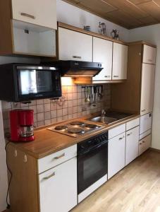 uma cozinha com armários brancos e um forno com placa de fogão em Turmhaus Trieben Wohnung 2 em Trieben