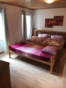 1 dormitorio con 1 cama grande con sábanas moradas en Turmhaus Trieben Wohnung 2, en Trieben