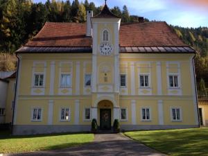 a large yellow building with a clock tower on it at Turmhaus Trieben Wohnung 2 in Trieben