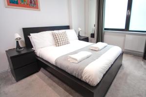 a bedroom with a bed with two towels on it at Stylish modern 1 bedroom property in Greenwich! in London