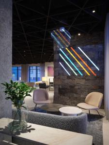 een lobby met stoelen en een muur met een schilderij bij Iceland Parliament Hotel, Curio Collection By Hilton in Reykjavík