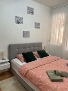 een slaapkamer met een bed met een roze dekbed bij Dioklecian Dream Apartment in Split