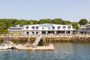 un edificio con muelle y un barco en el agua en Boothbay Harbor Inn, en Boothbay Harbor