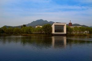 a building on the side of a body of water at Yanqi Hotel, Managed by Kempinski in Huairou