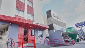 ein Hotel mit einem roten Zaun davor in der Unterkunft Hotel Goiânia Executive in Goiânia
