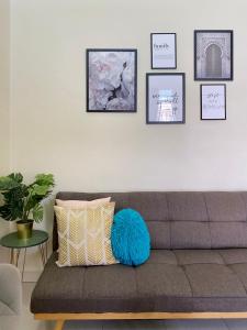 een woonkamer met een grijze bank en een blauw kussen bij RF Home - Home with 3 bedroom in Melaka