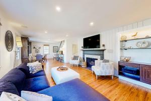 a living room with a blue couch and a fireplace at Serene Sanctuary - A Family Oasis in Falmouth