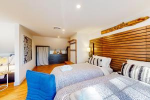 1 Schlafzimmer mit 2 Betten und einem Kopfteil aus Holz in der Unterkunft Serene Sanctuary - A Family Oasis in Falmouth