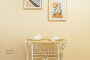 uma pequena mesa com duas chávenas e pratos em Cozy Studio Unit at Persimmon em Cebu