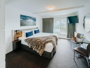a hotel room with a large bed and a desk at Falls Creek Hotel in Falls Creek