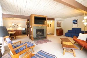 a living room with a blue couch and a fireplace at Beechwood 3, Lincoln, New Hampshire in Lincoln