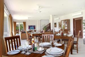 a dining room with wooden tables and chairs at Villa Yenian in Canggu