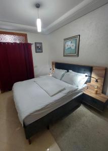 a bedroom with a large bed with a red curtain at Chabili Appartements in Temara
