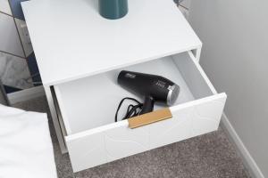 a white desk with a hair dryer in a drawer at Last min discount - Spacious 3b - Essentials near in Woolstone