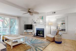 Una sala de estar con chimenea y televisión. en Driftwood Villa 270 - Sand Trap, en Edisto