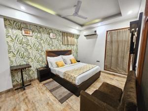a bedroom with a bed and a couch in it at Hotel AMADA Infinity Near Delhi Airport By LA CASA in New Delhi