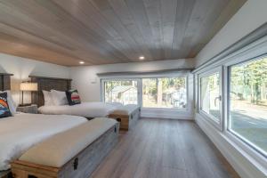 a bedroom with two beds and a large window at Village Camp in Truckee