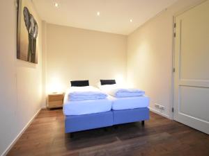 a bedroom with a bed with a blue foot board at Vrijzicht in Zuidwolde