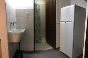 a bathroom with a sink and a toilet and a shower at Departamentos El Amanecer in Centenario