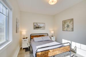 um quarto com uma cama com duas mesas de cabeceira e uma janela em Mankato Family Getaway - New Salt Water Hot Tub! em Mankato