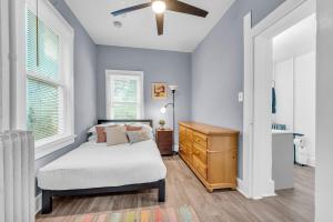 1 dormitorio con 1 cama, vestidor y ventanas en Cozy Med Haven: Little Italy, en Cleveland
