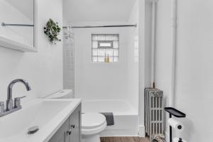 a white bathroom with a toilet and a sink at Cozy Med Haven: Little Italy in Cleveland