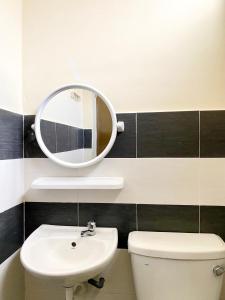 een badkamer met een wastafel en een spiegel boven een toilet bij RF Home - Home with 3 bedroom in Melaka