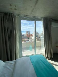 Un dormitorio con una cama y una ventana grande. en Turquoise Buenos Aires, en Buenos Aires