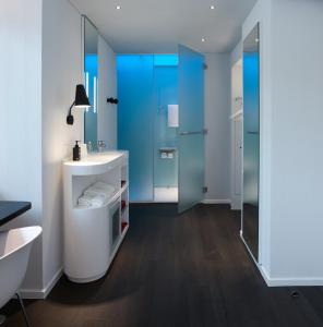 a bathroom with a sink and a glass shower at citizenM Kuala Lumpur Bukit Bintang in Kuala Lumpur