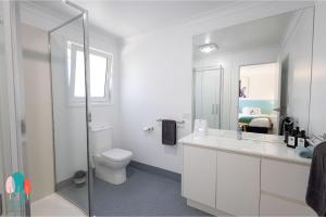 a bathroom with a toilet and a sink and a mirror at Botanic City Apartments in Warrnambool +101 photos