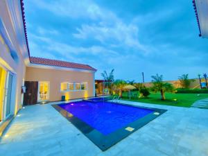 Gharayfahأستراحة أريـــان的房子后院的游泳池