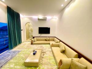 ein Wohnzimmer mit einem Sofa und einem Flachbild-TV in der Unterkunft أستراحة أريـــان in Gharayfah