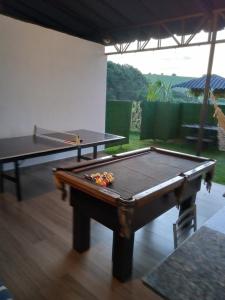 a ping pong table in a room with two tables at casa com bela vista em itatiba in Tijuco Prêto