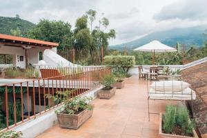Casa Del Calvario, 3BR Villa in Antigua Guatemala في أنتيغوا غواتيمالا: فناء مع طاولة وكراسي ومظلة