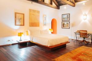 Casa Del Calvario, 3BR Villa in Antigua Guatemala في أنتيغوا غواتيمالا: غرفة نوم بسرير ومكتب وكرسي