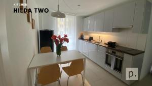una cocina con una mesa con un jarrón de flores. en H2 with 3,5 rooms, 2BR, living room and kitchen, central and quite en Zúrich