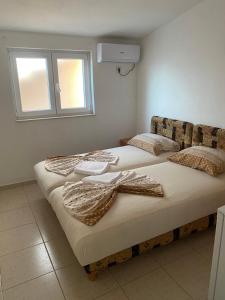 two beds sitting next to each other in a room at Apartmani ARIANA in Dobra Voda