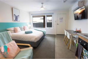 a living room with a bed and a table at Botanic City Apartments in Warrnambool