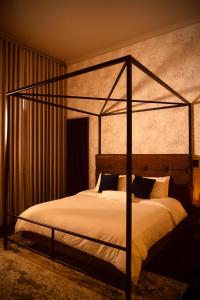 sypialnia z łóżkiem z metalowym baldachimem w obiekcie Hush Hush w mieście Barranquilla