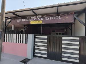 Ria Homestay & kolam في ألور سيتار: عماره فيها لوحه مكتوب عليها شاندان ترسم الروحانيه والاطفال