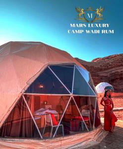 a woman standing in a tent in the desert at MARS lUXURY CAMP WADI RUM in Wadi Rum